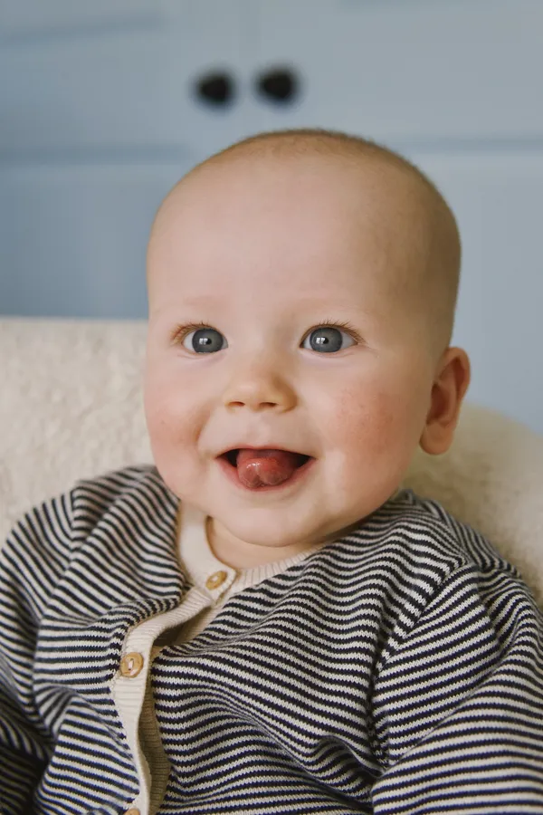 Baby laughing with a big smile during an indoor portrait session