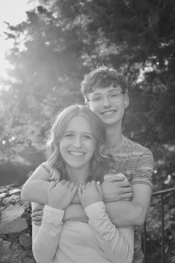 Couple embracing and laughing together in soft backlit sunlight, black and white