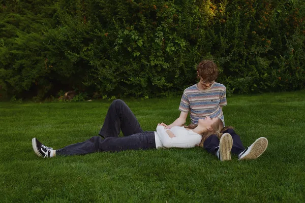 Couple relaxing together on a green lawn, candid and natural