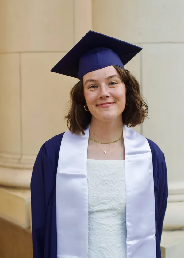 Close-up portrait of a woman smiling in graduation cap and gown